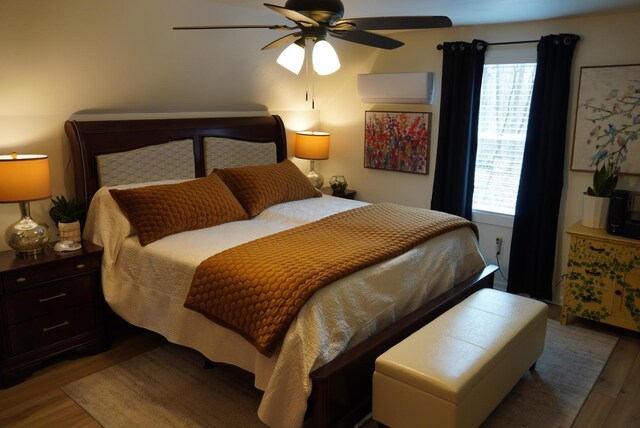 bedroom featuring a wall mounted air conditioner, ceiling fan, and wood finished floors