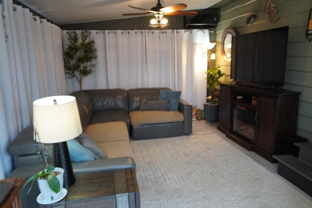 living area featuring light colored carpet, lofted ceiling, and ceiling fan