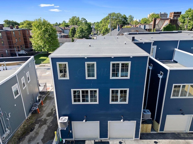 back of property featuring ac unit and a garage