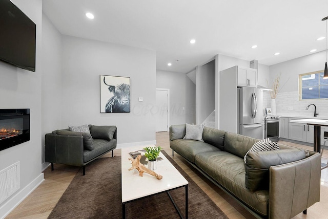 living area featuring visible vents, recessed lighting, and light wood finished floors