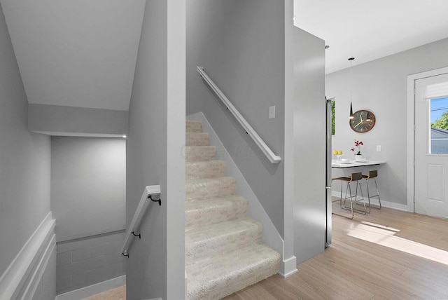 staircase with baseboards and wood finished floors