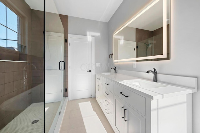bathroom featuring double vanity, a sink, tile patterned floors, and a shower stall