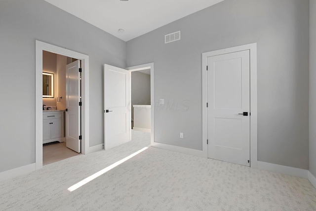 unfurnished bedroom with baseboards, visible vents, carpet, and ensuite bath