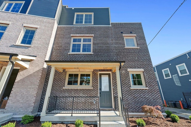 view of front of house with covered porch and brick siding