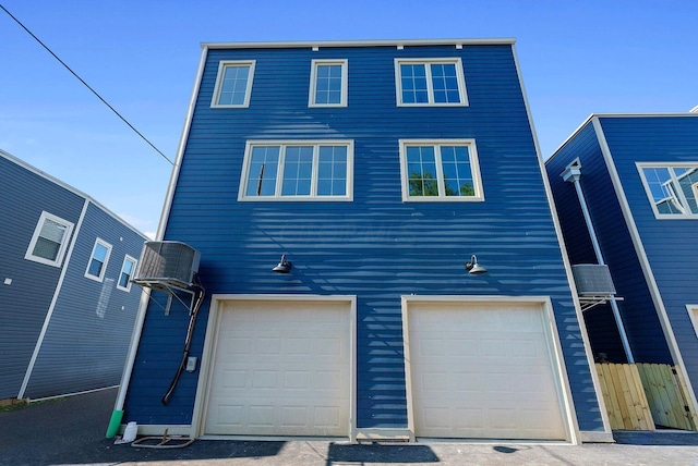 exterior space featuring fence and an attached garage
