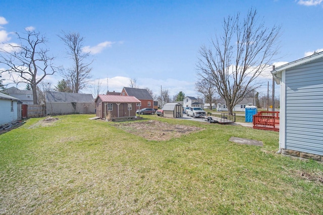 view of yard with a storage unit, an outdoor structure, and fence
