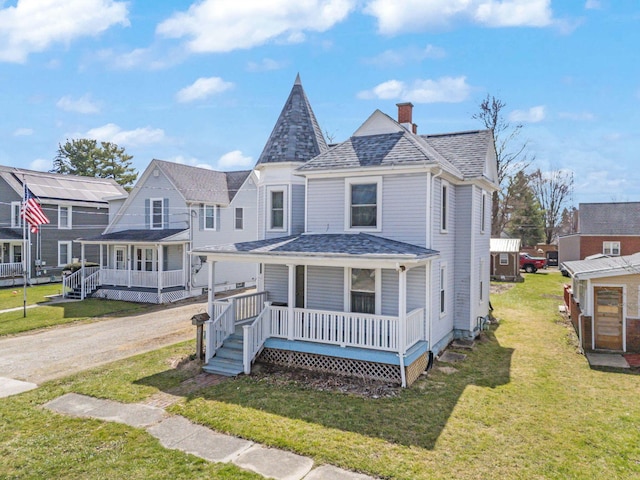 victorian house featuring a shingled roof, a chimney, a porch, and a front yard