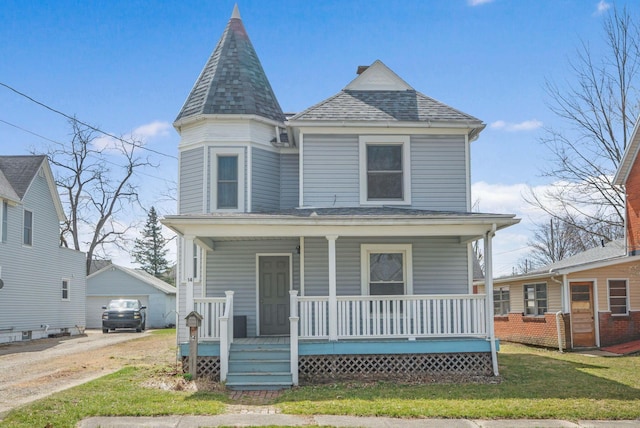 victorian house featuring a front yard, an outbuilding, a porch, and roof with shingles