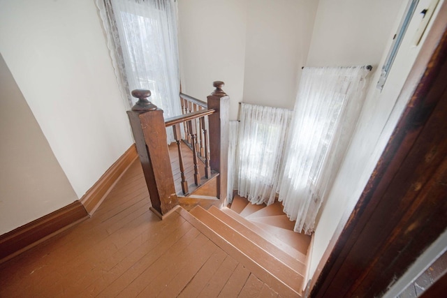 staircase featuring baseboards and wood-type flooring