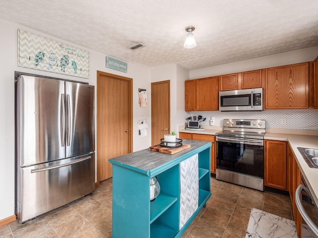 kitchen featuring open shelves, appliances with stainless steel finishes, brown cabinetry, visible vents, and decorative backsplash