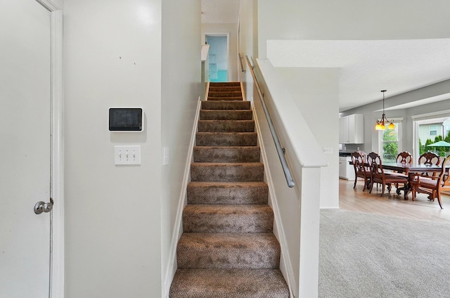 stairway featuring carpet flooring and baseboards