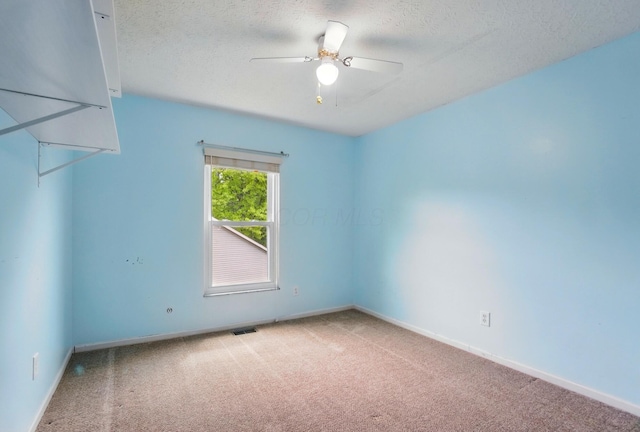 carpeted empty room featuring a textured ceiling, baseboards, and a ceiling fan