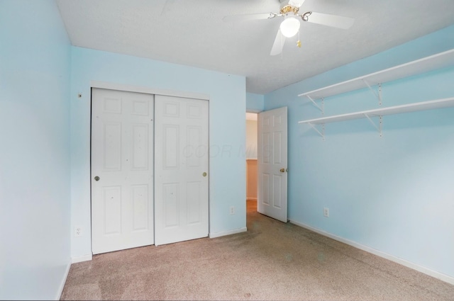 unfurnished bedroom featuring carpet flooring, a closet, baseboards, and a ceiling fan