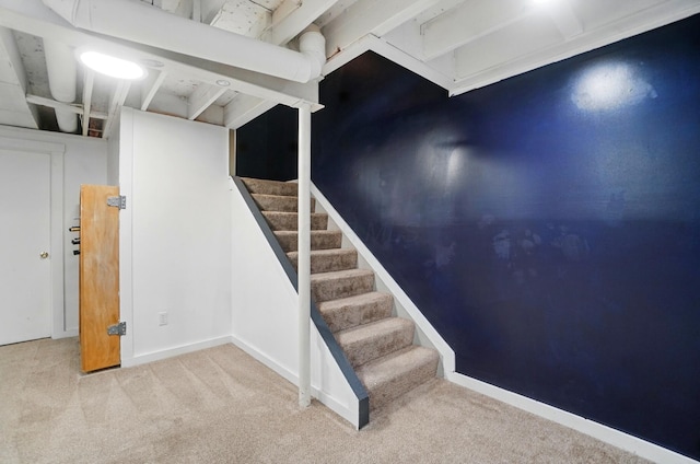 finished below grade area featuring carpet flooring and stairway