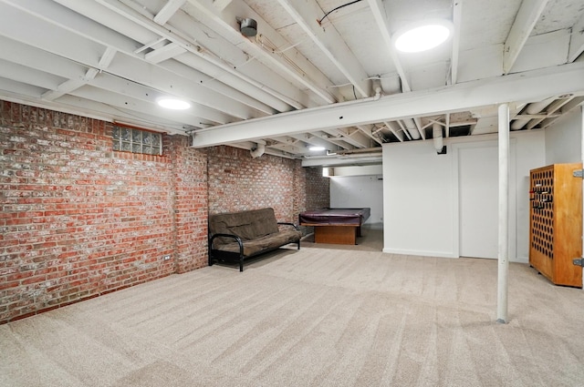 finished below grade area with brick wall and carpet flooring
