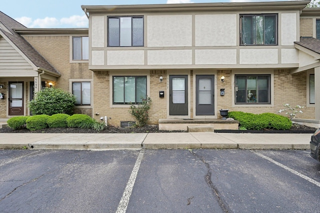 5692 Great Hall Ct, Columbus, OH 43231 - view of front facade with uncovered parking, brick siding, and stucco siding