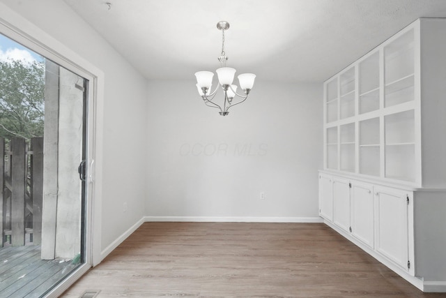 5692 Great Hall Ct, Columbus, OH 43231 - unfurnished dining area with a chandelier, light wood-type flooring, and baseboards