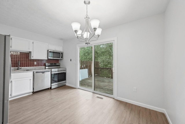5692 Great Hall Ct, Columbus, OH 43231 - kitchen with appliances with stainless steel finishes, light countertops, decorative backsplash, and white cabinets