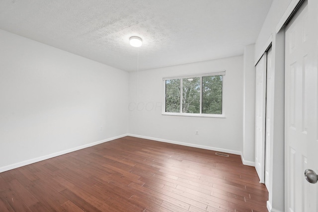 5692 Great Hall Ct, Columbus, OH 43231 - unfurnished bedroom with baseboards, dark wood-type flooring, a closet, and a textured ceiling