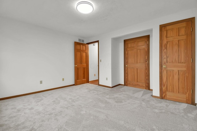 unfurnished bedroom featuring visible vents, baseboards, carpet flooring, and a textured ceiling
