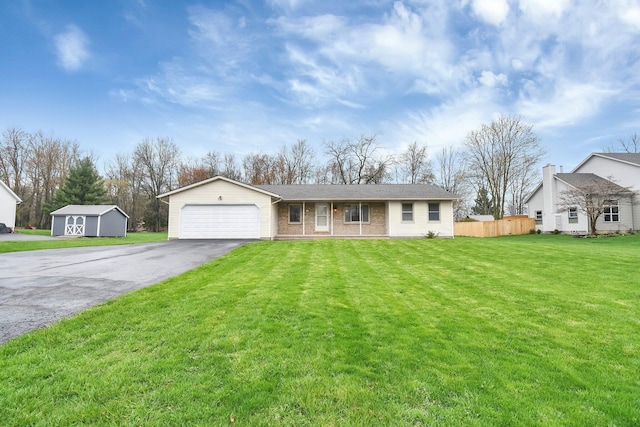 ranch-style house featuring aphalt driveway, fence, a front lawn, brick siding, and an attached garage