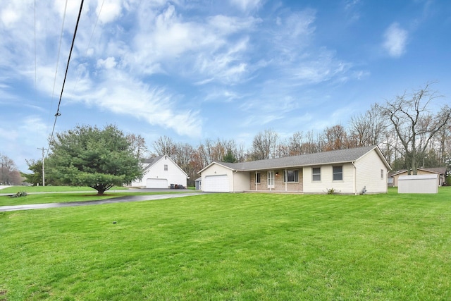 view of front of house featuring driveway, a front lawn, and an attached garage