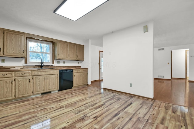 kitchen with light wood finished floors, visible vents, a sink, and black dishwasher