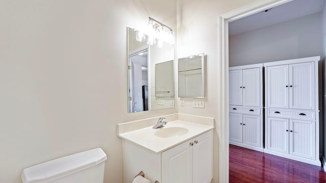 bathroom featuring toilet, vanity, and wood finished floors