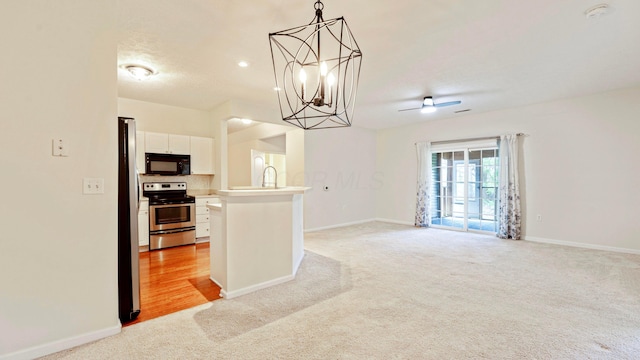 kitchen featuring light colored carpet, open floor plan, stainless steel appliances, and baseboards