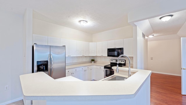 kitchen featuring tasteful backsplash, white cabinets, appliances with stainless steel finishes, and baseboards