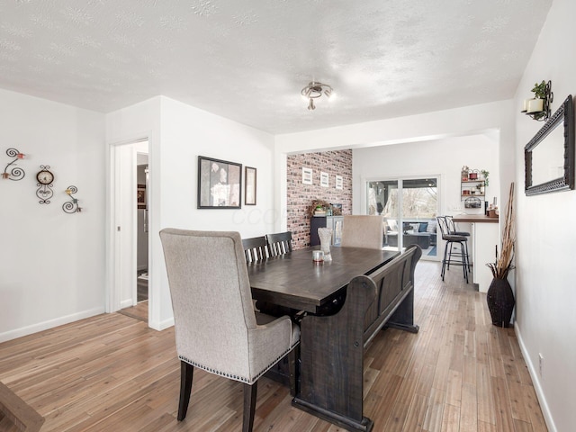 2600 Seneca Dr, London, OH 43140 - dining space featuring baseboards, a textured ceiling, and light wood finished floors