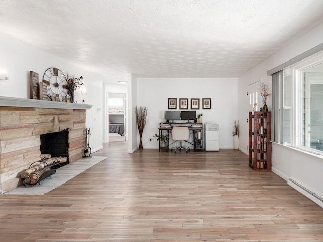 2600 Seneca Dr, London, OH 43140 - living area featuring a fireplace, wood finished floors, a textured ceiling, a baseboard radiator, and baseboards