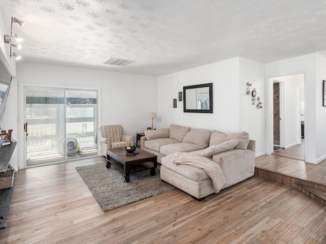2600 Seneca Dr, London, OH 43140 - living room with hardwood / wood-style floors, a textured ceiling, baseboards, and visible vents