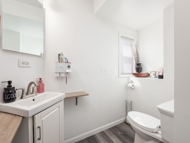 2600 Seneca Dr, London, OH 43140 - bathroom with baseboards, toilet, vanity, and wood finished floors