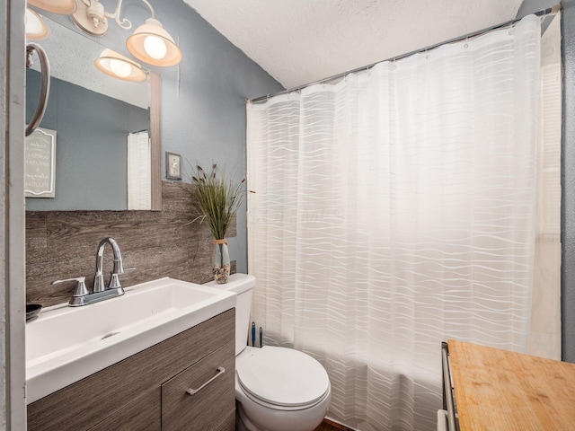 bathroom featuring backsplash, toilet, vanity, and a textured ceiling