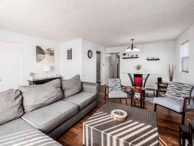 living area featuring a textured ceiling, wood finished floors, and a notable chandelier