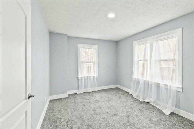 8119 State Route 366, Russells Point, OH 43348 - carpeted empty room with baseboards and a textured ceiling