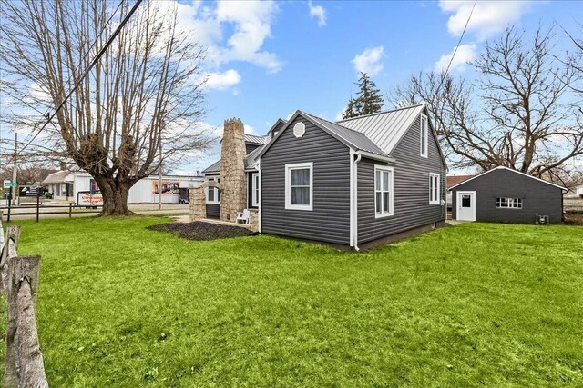 8119 State Route 366, Russells Point, OH 43348 - view of side of home featuring a chimney, a lawn, fence, and metal roof