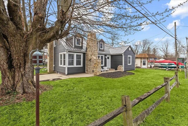 8119 State Route 366, Russells Point, OH 43348 - back of house with metal roof, fence, a patio, a chimney, and a yard