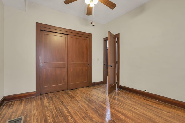 unfurnished bedroom featuring baseboards, visible vents, a ceiling fan, and wood-type flooring
