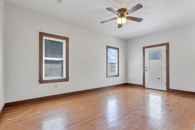 spare room with baseboards, ceiling fan, and hardwood / wood-style floors