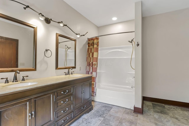 full bathroom with baseboards, double vanity, a sink, and shower / bath combo with shower curtain
