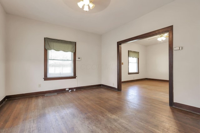 empty room featuring baseboards, ceiling fan, and hardwood / wood-style flooring
