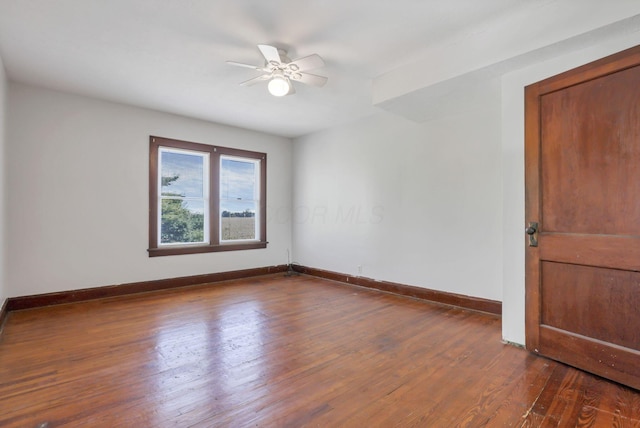 spare room with hardwood / wood-style floors, ceiling fan, and baseboards