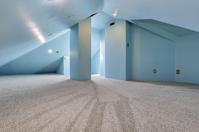 bonus room with carpet flooring and vaulted ceiling