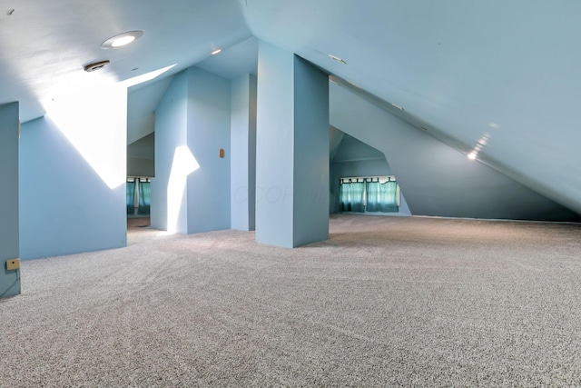 additional living space featuring carpet floors and lofted ceiling