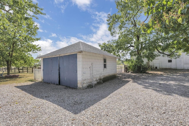 view of outdoor structure featuring an outbuilding and fence