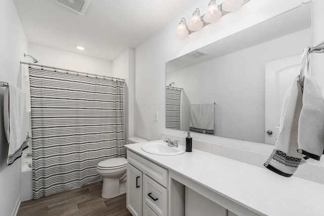 full bath with toilet, vanity, a shower with curtain, wood finished floors, and visible vents