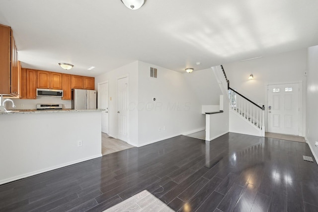 1143 Green Knoll Dr, Westerville, OH 43081 - unfurnished living room with stairs, a sink, wood finished floors, baseboards, and visible vents