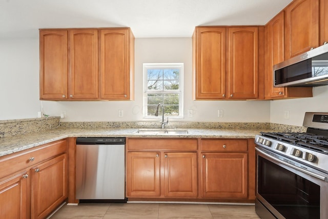 1143 Green Knoll Dr, Westerville, OH 43081 - kitchen featuring light stone counters, brown cabinetry, a sink, and stainless steel appliances
